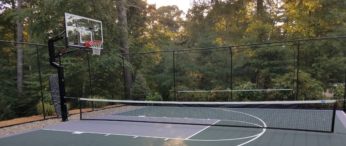 VersaCourt rebounder net at the end of a backyard court